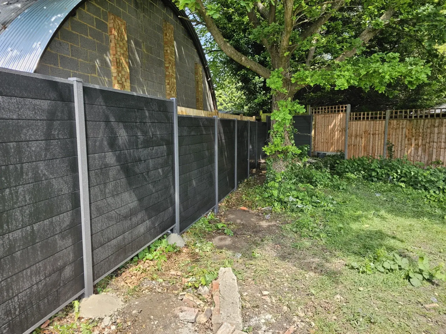Dark composite fencing with concrete posts